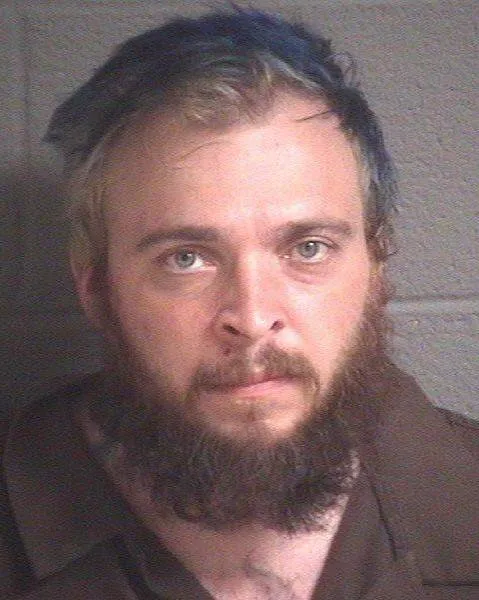 Sean Ball in a booking photo, with a full beard