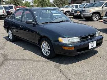 A dark green 1997 Toyota Corolla sedan parked in a lot